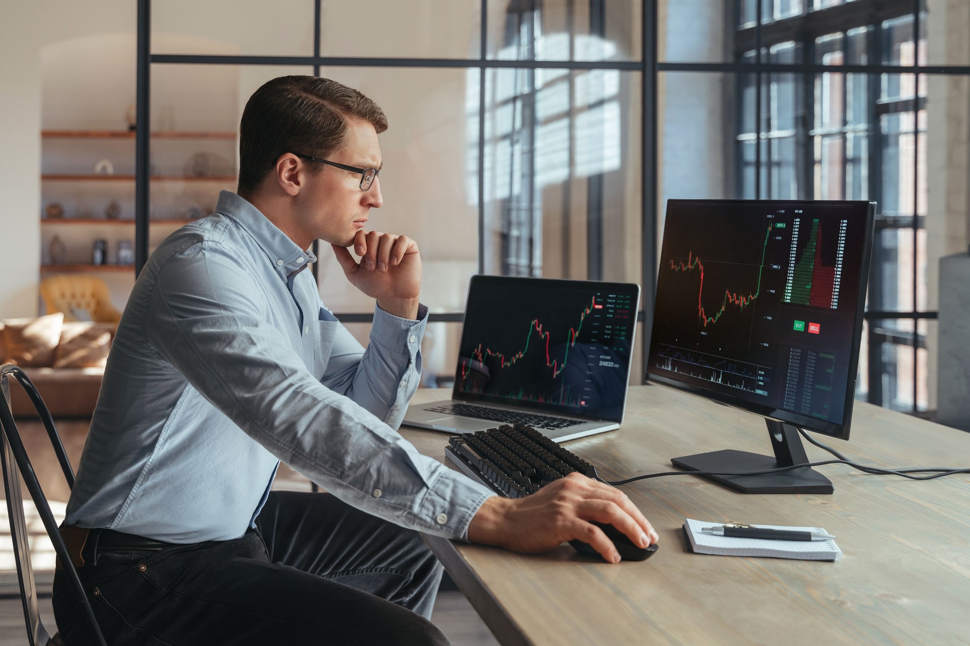 Trader analyst at office analyzing indexes, financial chart, trading online at his PC